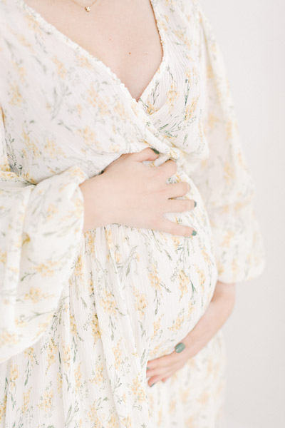 Zwangerschapsshoot boudoir in de studio met haarstyling, visagie en zwangerschapsjurken uit de client closet. Lichte, ontspannen zwanger en newborn fotoshoot. Fotograaf baby’s eerste jaar