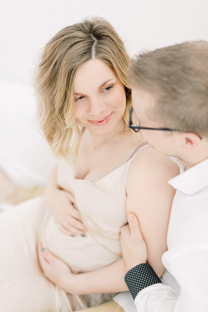 Zwangerschapsshoot boudoir in de studio met haarstyling, visagie en zwangerschapsjurken uit de client closet. Lichte, ontspannen zwanger en newborn fotoshoot. Fotograaf baby’s eerste jaar. Zwangerschapsfotograaf Brabant. Zwangerschapsfoto met partner