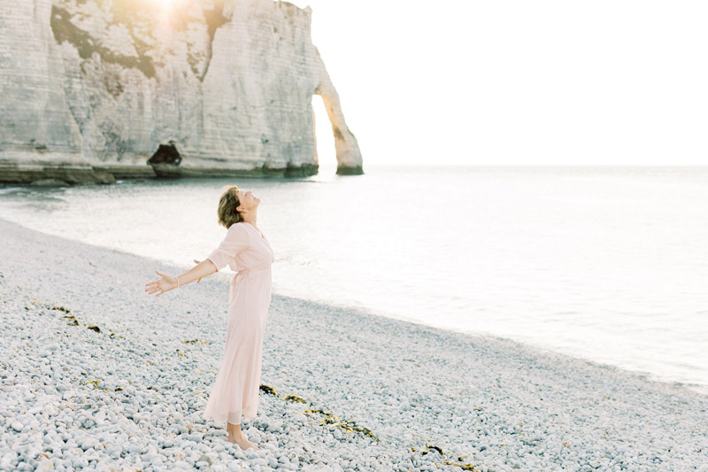 Spirituele business branding fotoshoot Danielle Blessing in Étretat Normandië Frankrijk aan de kust op het strand aan zee met rotsen foto's vol vrijheid en detail lichte stijl fotografie portret shoot fotograaf met client closet light and airy photoshoot at the sea in Normandy France