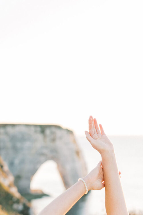 Spirituele business branding fotoshoot Danielle Blessing in Étretat Normandië Frankrijk aan de kust op het strand aan zee met rotsen foto's vol vrijheid en detail lichte stijl fotografie portret shoot fotograaf met client closet light and airy photoshoot at the sea in Normandy France