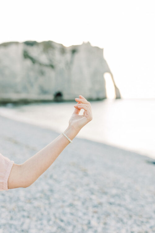 Spirituele business branding fotoshoot Danielle Blessing in Étretat Normandië Frankrijk aan de kust op het strand aan zee met rotsen foto's vol vrijheid en detail lichte stijl fotografie portret shoot fotograaf met client closet light and airy photoshoot at the sea in Normandy France