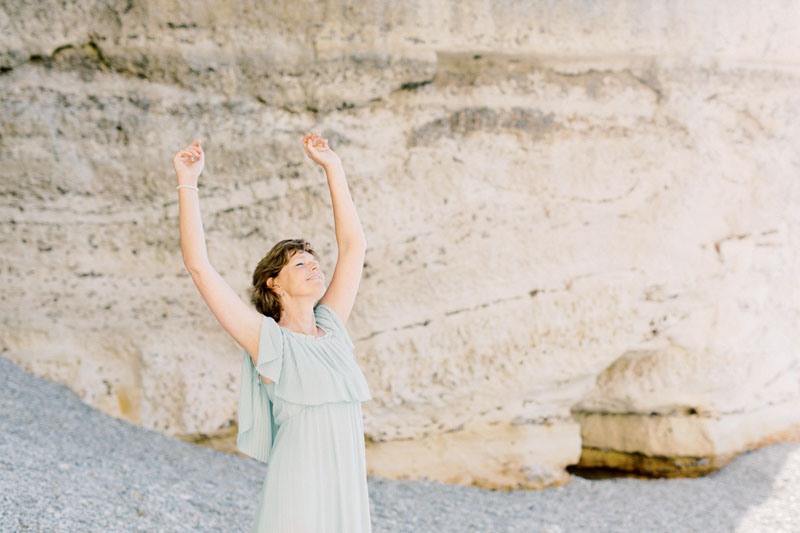 Spirituele business branding fotoshoot Danielle Blessing in Étretat Normandië Frankrijk aan de kust op het strand aan zee met rotsen foto's vol vrijheid en detail lichte stijl fotografie portret shoot fotograaf met client closet light and airy photoshoot at the sea in Normandy France