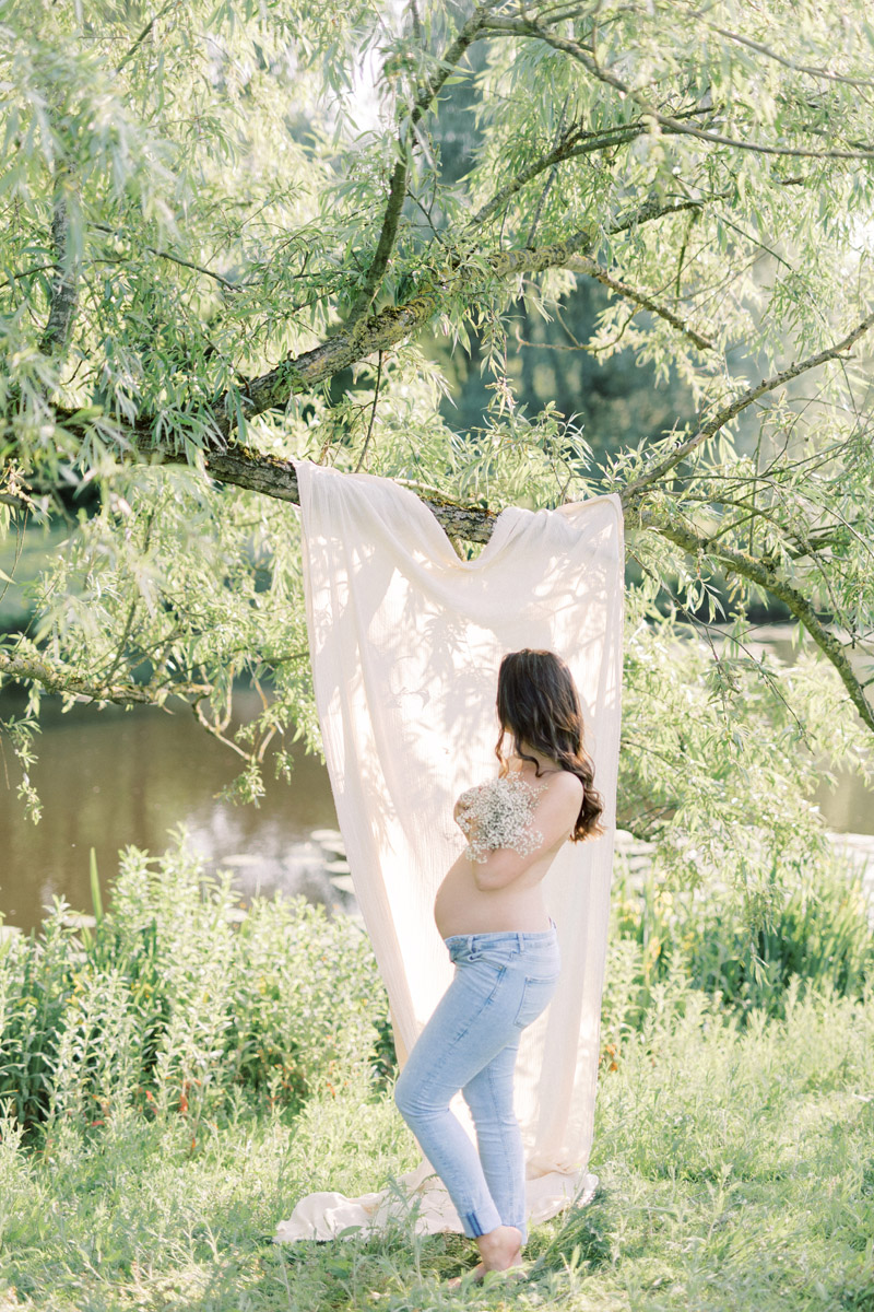 Zwangerschapsshoot boudoir met lingerie in de natuur achtergronddoek in boom zwanger boudoirshoot fotoshoot licht natuurlijk naturel roze pastel light and airy maternity session boudoirfoto's buiten zwangerschapsboudoir met bloemen lichte stijl foto's zwangerschapsfotograaf photoshoot in nature Dutch pregnancy photographer romantic Fine art fotograaf Milou van Ham Fotografie in Amsterdam Noord Holland Zuid Holland