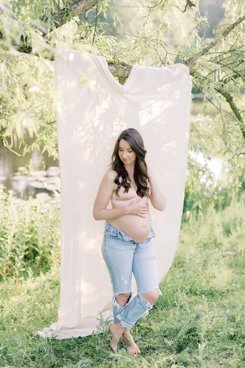 Zwangerschapsshoot boudoir met lingerie in de natuur achtergronddoek in boom zwanger elegante boudoirshoot fotoshoot jeans en bh licht natuurlijk naturel roze pastel light and airy maternity session boudoirfoto's buiten stoer en sexy zwangerschapsboudoir met bloemen lichte stijl foto's zwangerschapsfotograaf photoshoot in nature Dutch pregnancy photographer romantic Fine art fotograaf Milou van Ham Fotografie in Amsterdam Noord Holland Zuid Holland